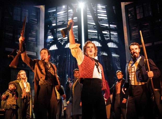 Ashley Gilmour as Enjolras and the company of Les Misérables