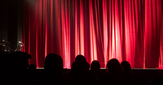 A curtain down in front of an audience