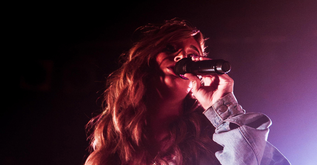 A singer with a microphone in their left hand