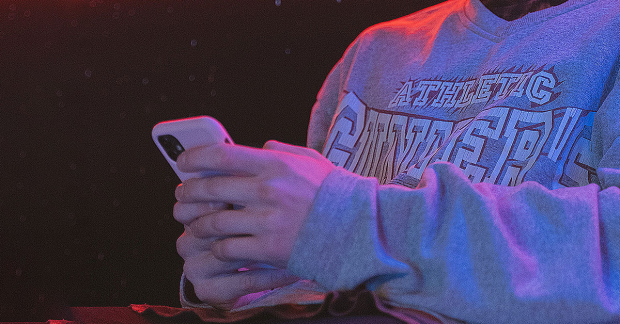 A stock photo of someone using their phone in the dark